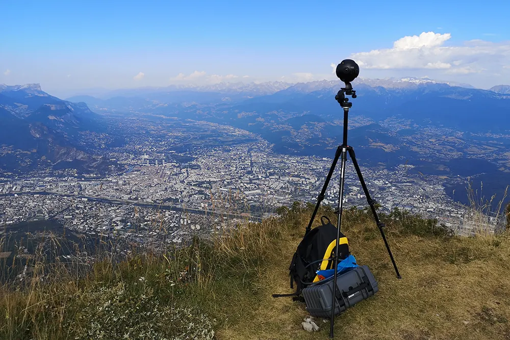 360° camera on a tripod overlooking an alpine valley