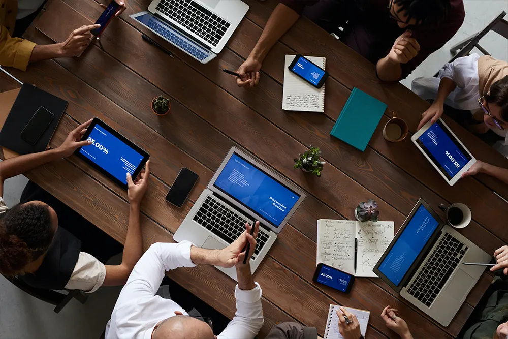 Team meeting around laptops, seen from above